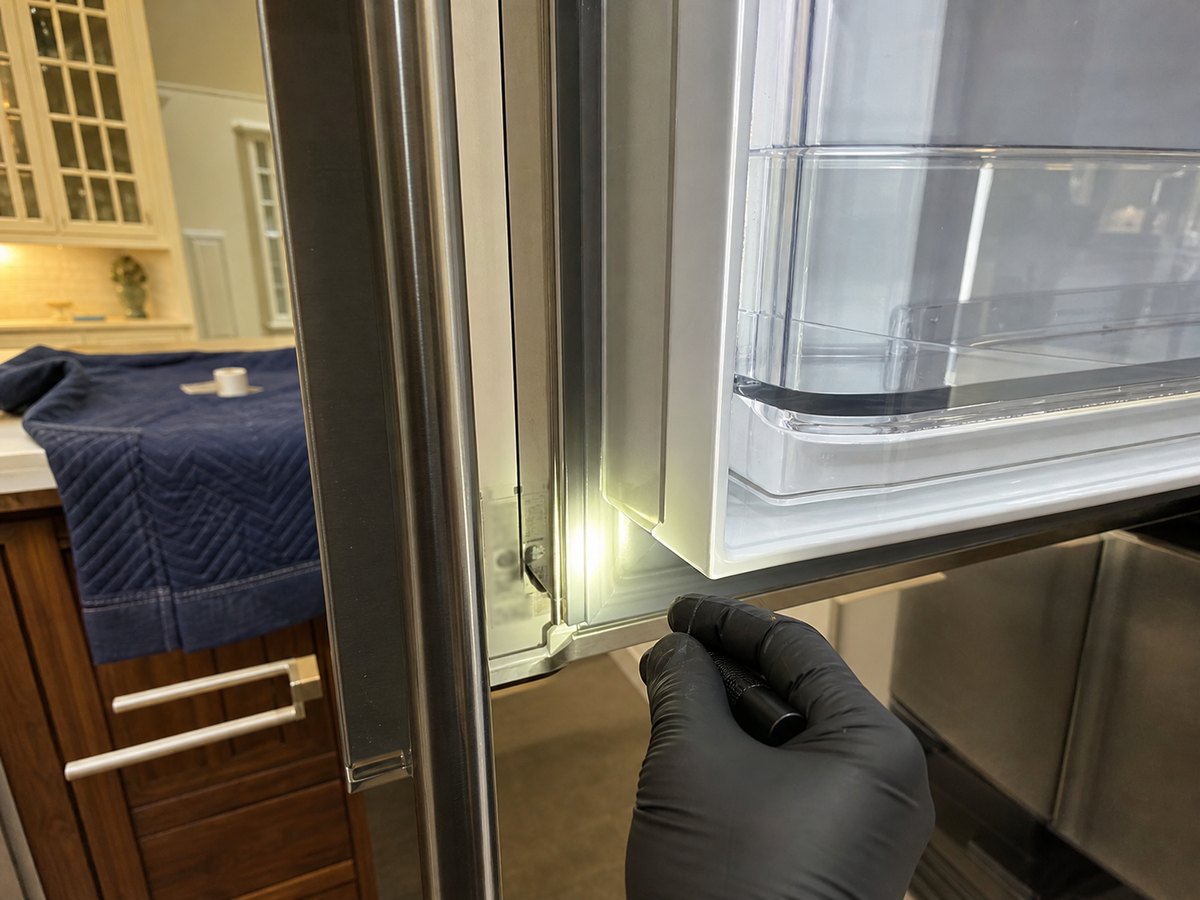 Panel-ready refrigerator door and cabinet access prepared for a service visit